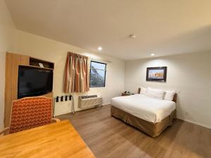 a bedroom with a bed and a flat screen tv at Jolly Roger Hotel in Los Angeles