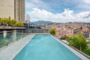 a swimming pool on the roof of a building with a city at Appartments Pool and Rooftop Downtown Hotel in Medellín