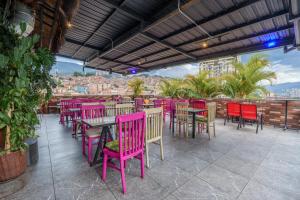 a restaurant with pink chairs and tables with a view at Appartments Pool and Rooftop Downtown Hotel in Medellín