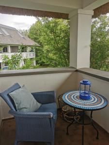 a porch with a table and a chair and a window at Seepark Weiden - Baumhof in Weiden am See