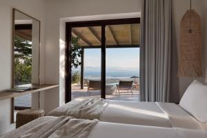 a bedroom with a bed and a view of the ocean at Anemones Villas by Omikron Selections in Spanokhórion