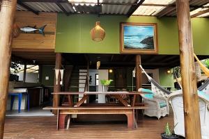 a patio with a wooden table and a bench at Casa da Ale e do Thi - Ilha do Mel in Ilha do Mel