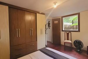 a bedroom with a bed and wooden cabinets and a window at Casa da Ale e do Thi - Ilha do Mel in Ilha do Mel +47 photos