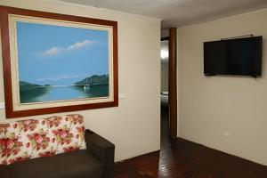 a living room with a couch and a flat screen tv at Casa da Ale e do Thi - Ilha do Mel in Ilha do Mel