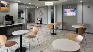 a waiting room with tables and chairs and a tv at Motel 6-Weslaco, TX in Weslaco