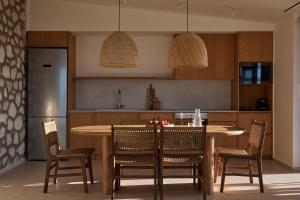 a kitchen with a wooden table and chairs at Anemones Villas by Omikron Selections in Spanokhórion +52 photos