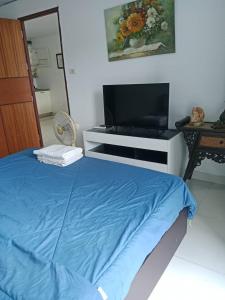 a bedroom with a bed and a flat screen tv at Neo2 condo 703 in Jomtien Beach