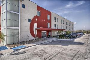 a red and white building with cars parked in a parking lot at Motel 6-Weslaco, TX in Weslaco