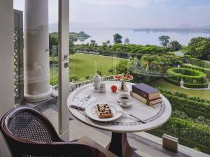 a table with a plate of food on top of a balcony at Raffles Udaipur in Udaipur +265 photos