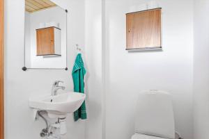 a white bathroom with a sink and a toilet at 6707-Ronne-Kallokkevej-5 in Rønne