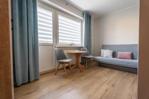 a room with a bed and a table and chairs at Magdalena in Karwia