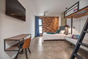 a bedroom with a bunk bed and a desk and a couch at Appartments Pool and Rooftop Downtown Hotel in Medellín