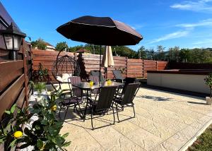 a table and chairs with an umbrella on a patio at Vila Jovanovic in Bajina Bašta