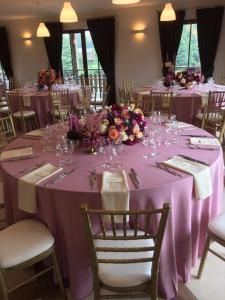 a table with purple table cloths and flowers on it at Luokesų Dvaro sodyba in Ažuluokesa