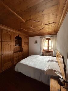 a bedroom with a bed and a wooden ceiling at Panorama Lodge in Cortina dʼAmpezzo
