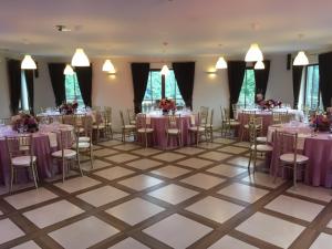 a banquet hall with tables and chairs with purple tablecloths at Luokesų Dvaro sodyba in Ažuluokesa