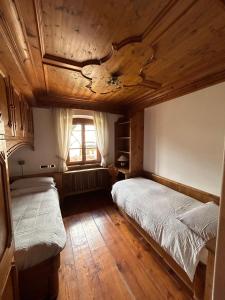 a bedroom with two beds and a window at Panorama Lodge in Cortina dʼAmpezzo