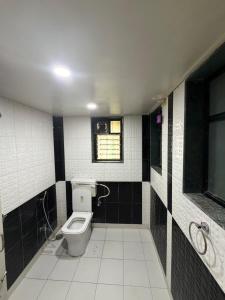a bathroom with a toilet and a window at The Highstreet Stay in Pune