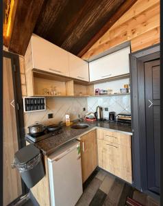 a small kitchen with wooden cabinets and a refrigerator at Yeşilsu Taş Konağı in Yeşilsu