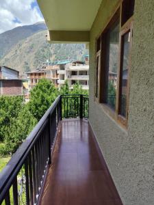a balcony with a view of a building at Katha Inn in Manāli