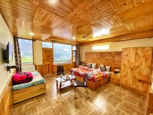 a bedroom with a bed and a table in a room at Katha Inn in Manāli