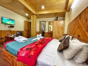 a bedroom with a large bed with swans on it at Katha Inn in Manāli +24 photos