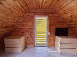a room with a wooden wall with a door and a television at Hygge in Brenno +3 photos