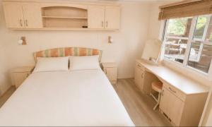 a small bedroom with a bed and a desk at Parc Montana - Mobile home in Gassin +10 photos
