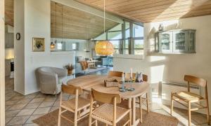 a dining room and living room with a table and chairs at VE087-Vejers-Strand-Jafdalvej-41 in Vejers Strand