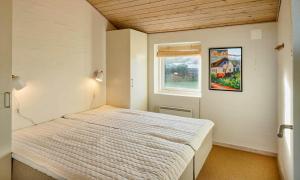 a bedroom with a bed in a room with a window at VE087-Vejers-Strand-Jafdalvej-41 in Vejers Strand