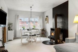 a living room with a table and a fireplace at 80320-Ulfborg-Reberbanen-4 in Ulfborg