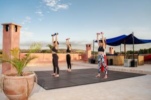 a group of people doing a yoga pose on a roof at Casa Misasha, pool & rooftop-5 suites-13 lits-hamam in Essaouira