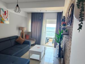 a living room with a couch and a table at Beachfront Dream, WaveHaus in Akouda