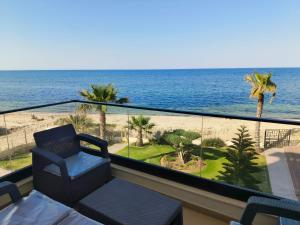 a balcony with a chair and a view of the beach at Beachfront Dream, WaveHaus in Akouda