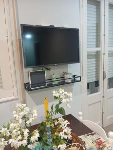 a living room with a television and a table with flowers at Casa Viñao in Boborás