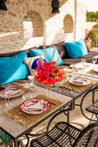 a table with plates and a vase of flowers on it at Casa Misasha, pool & rooftop-5 suites-13 lits-hamam in Essaouira