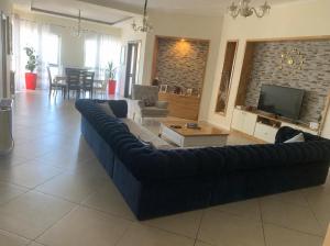 a living room with a blue couch and a tv at Vila Era in Shëngjin