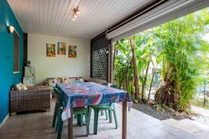 a room with a table and chairs on a patio at Gites villa bagatelle piscine et Plage à 900m in Sainte-Rose