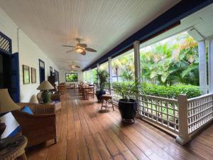 a large room with a porch with chairs and tables at La Posada Azul Boutique Hotel Coco SA in San Juan del Sur