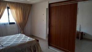 a bedroom with a bed and a wooden closet at Elite appart in Dakar
