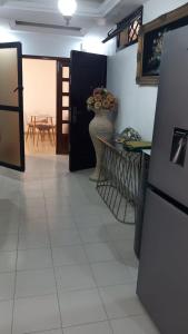 a kitchen with a refrigerator and a table with a vase of flowers at Elite appart in Dakar