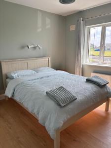 a bedroom with a bed with two towels on it at Beach view Bungalow in Spanish Point