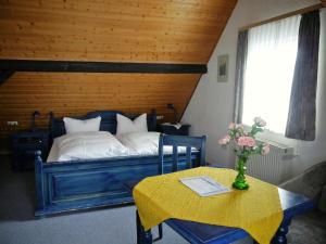 a bedroom with a bed and a table with a vase of flowers at Hotel-Gasthof-Destille-Eisenbahn in Mosbach