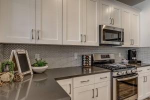 a kitchen with white cabinets and a stove top oven at Long Stays Welcome! Pet Friendly & Heated Pool in Washington +10 photos