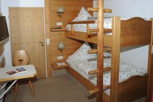 a bedroom with two bunk beds with a desk at Gästehaus Nigg in Eisenberg