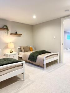 a bedroom with two beds and a lamp at Ivy s House in West Vancouver