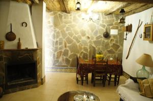 a living room with a table and a fireplace at El Garrotal in El Bosque