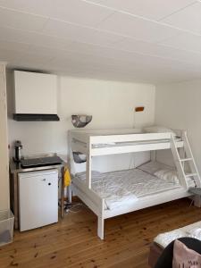 a white bunk bed in a room with a kitchen at SleepCleanGo L3 in Gnisvärd