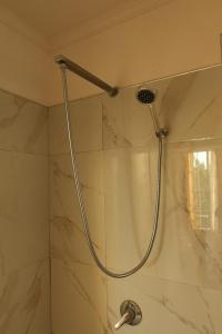 a shower with a shower head in a bathroom at Esal Hotel in Durrës
