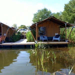 a gazebo on the water with two chairs at Safaritent 4 in Biddinghuizen